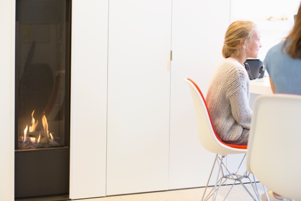 De haard staat aan en een patiënt zit aan de bureau.